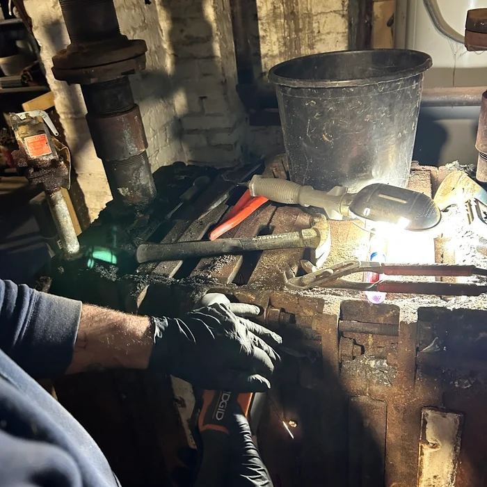 The original boiler being dismantled during replacement work.