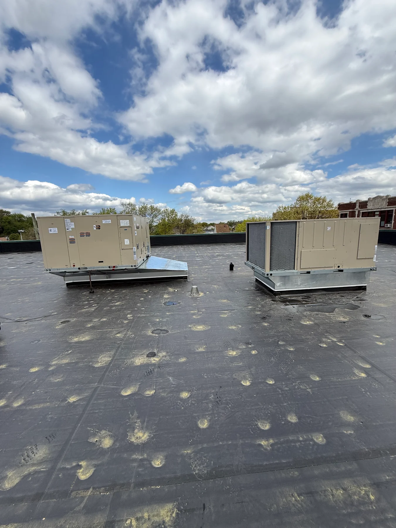 Two large HVAC units on raised metal bases on a flat commercial roof.